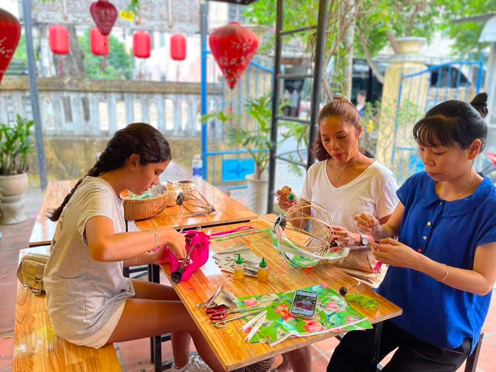 Touristes qui fabriquent des lanternes à Hoi An